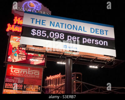 Las Vegas, USA. April 2021. Spät in der Nacht auf dem Las Vegas Strip die ständig wachsende Staatsschuldenuhr. Die Schulden der Vereinigten Staaten sind aufgrund der COVID-Konjunktur auf Rekordniveau gestiegen. Stockfoto