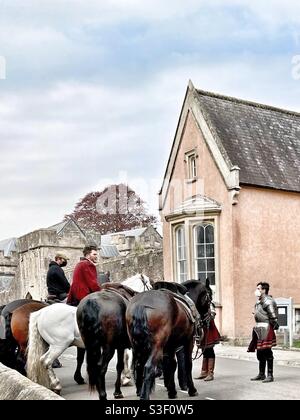 Ritter in Rüstung trägt eine Gesichtsmaske, während er sich sozial von einer Fernsehserie distanziert, die in Wells, Somerset, Großbritannien, spielt und dabei zu einem Elizabeth- amerikanischen Fernsehdrama wird Stockfoto