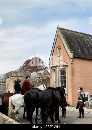 Dreharbeiten zur amerikanischen Fernsehserie Becoming Elizabeth in Wells Somerset Direkt vor der Kathedrale von Wells am 28/04/21 - Ritter in Rüstung Mit einer Gesichtsmaske - Tudor kleidet Männer zu Pferd Stockfoto