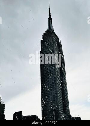 Das Empire State Building wird durch das durch Regen verspritzte Fenster gesehen Stockfoto