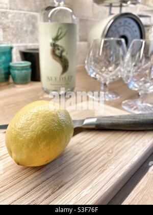 Seedlip alkoholfreier Gin und Tonic - destillierter Alkohol - Getränke machen - Zitrone auf einem Schneidebrett Stockfoto