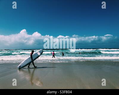 Ein Surfer, der am Strand in der Bucht von Sennen entlang läuft Cornwall Stockfoto