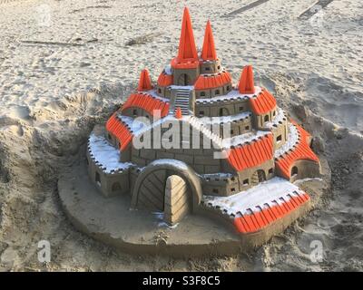 Große Sandburg in Orange und Sandfarbe am Strand in Palavas les Flots in der Nähe von Carnon Plage und Montpellier, Ockitanie, Südfrankreich Stockfoto