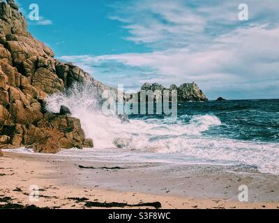 Wellen krachen am strand von porthcurno in Cornwall Stockfoto