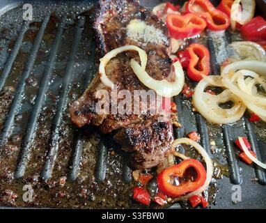 Serlion Steak on Griddle mit Paprika, Zwiebeln, Chili mit Kräutern und West Country Butter Stockfoto