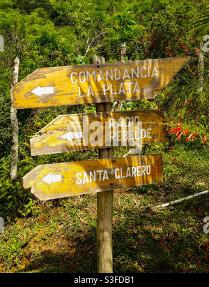 Hölzerne Wegweiser mit Hinweisen zu Orten in den Bergen der Sierra Maestra, die mit den Verstecken der revolutionäre während der kubanischen Revolution, Kuba, verbunden sind Stockfoto