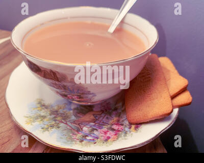 Tee und Bickies, Tasse Tee mit Milch in einem altmodischen Vintage feine porzellan-Tee-Tasse und Untertasse, traditionellen Stil, Teelöffel Stockfoto