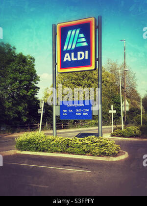 Das berühmte Aldi-Logo auf einem großen Schild vor dem Eingang des Parkplatzes für Lebensmitteleinzelhändler. Aldi ist ein britischer Billighändler, der schnell Marktanteile gewinnt. Bildnachweis - ©️ COLIN HOSKINS. Stockfoto