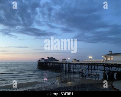 Cromer Pier an einem Sommerabend, beleuchtet, wenn die Sonne untergeht. Norfolk, Großbritannien Stockfoto