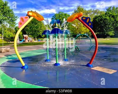 Splash Pad mit Wasserbrunnen, modernes Märchenland in einem Park, Ontario, Kanada. Beliebter Ort für Abkühlung und Spaß im Frühling, Sommer und frühen Herbst. Stockfoto