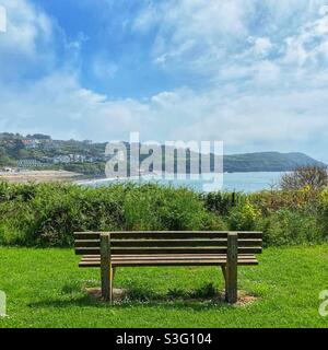 Ein Foto einer Holzbank auf einem Aussichtspunkt über der Langland Bay auf der Gower Peninsula, Wales Stockfoto