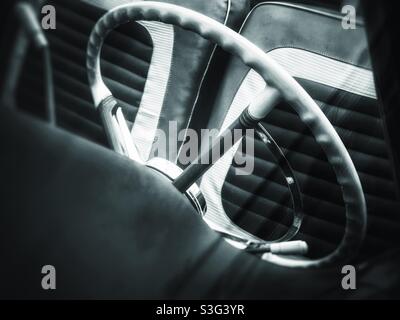 Oldtimer-Lenkrad und Vordersitz in Schwarz und Weiß Stockfoto