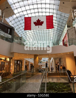Kanadische Flagge hängt von der Glasdecke des Core Shopping Centers. Downtown Calgary, Alberta, Kanada. Stockfoto