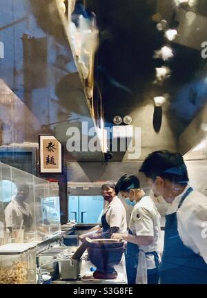 Köche und Köche kochen in der Küche des thailändischen Restaurants Samsen in Wan Chai, Hongkong. Stockfoto