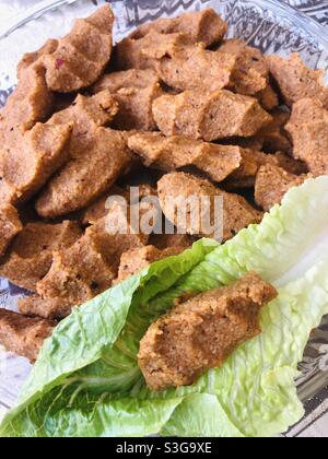 Türkische vegane Gericht Cig Kofte, von denen die Hauptzutat Bulgur Weizen ist. Es wird mit Salat und anderem Gemüse serviert Stockfoto