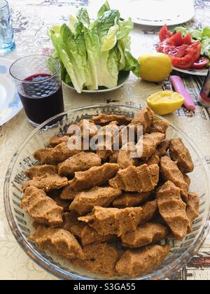 Türkisches veganes Gericht namens Cig Kofte, das mit Gemüse und Rübensaft serviert wird Stockfoto