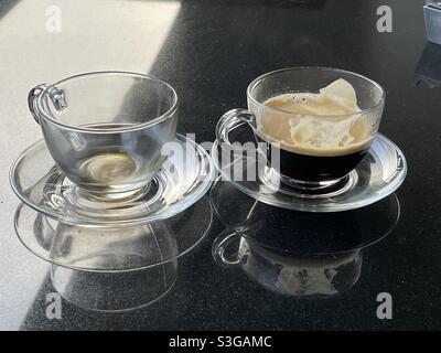 Leere Tasse und halbvolle Tasse frisch gebrühten Kaffee Stockfoto