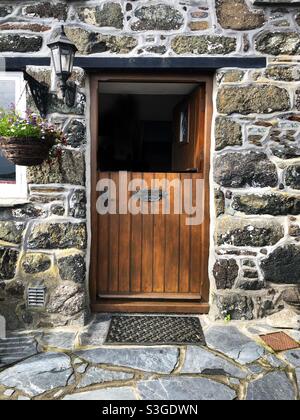 Eine halb offene stabile Tür zu einem schönen und traditionellen Steinhaus Stockfoto
