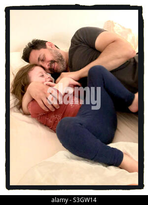 Vater und Kleinkind Sohn lachen und kuscheln in ihrem Haus. Stockfoto