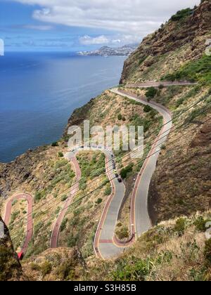 Kurvenreiche Straße mit Kehren, die nach Praia de Garajau, Santa Cruz, Madeira hinunter führen. Stockfoto