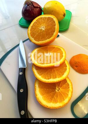 Nahaufnahme von Obst und einer roten Zwiebel auf einem Schneidebrett in einer Wohnküche, USA Stockfoto