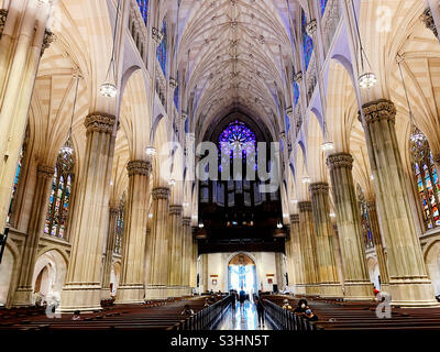 Die St. Patrick's Cathedral in der Fifth Avenue verfügt über ein riesiges Fleckglasfenster, das vom Hauptgang, NYC, USA, aus gesehen wird Stockfoto