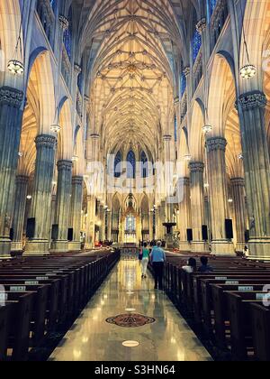 Der Hauptgang und Holzbänke mit Blick auf den Altar in der St. Patrick’s Cathedral auf der Fifth Ave., NYC, USA Stockfoto