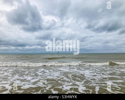 Ein Boot in der Ferne auf einem rauschigen Meer unter einem stürmischen Himmel in East Sussex Stockfoto