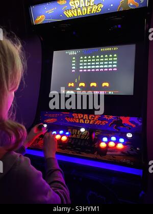 Teenager spielt auf einer Retro-Arcade-Space Invaders Machine Stockfoto