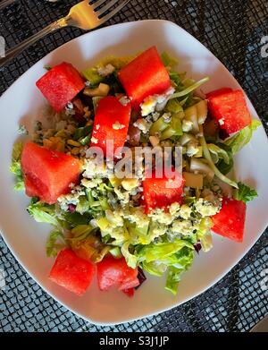 Grüner Salat mit Wassermelonenwürfeln und blauen Käsebröseln. Stockfoto