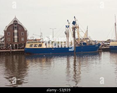 Ein blaues Fischerboot liegt im Hafen oudeschild der niederländischen Nordseeinsel texel Stockfoto