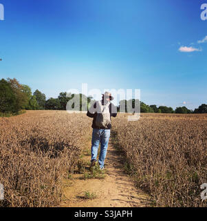 Mann, der mit einem australischen Hut über ein Feld läuft Stockfoto