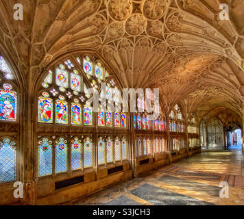 Der Kreuzgang der Gloucester Cathedral in England, Großbritannien. Tolle Buntglasfenster und gewölbte Decken mit Ventilatoren. Dieser Bereich wurde als Drehort für zwei Harry Potter Filme genutzt. Foto ©️ COLIN HOSKINS. Stockfoto