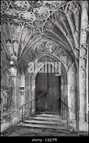 Der hölzerne Eingang, der den Bereich Cloisters von der gotischen Kathedrale in Gloucester, England, Großbritannien, trennt. Berühmt für seine gewölbten Deckendesigns und Harry Potter-Filme. Foto ©️ COLIN HOSKINS. Stockfoto