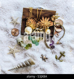Piratenschatzschatz mit Sand, Totenköpfen, Muscheln und Beute! Stockfoto