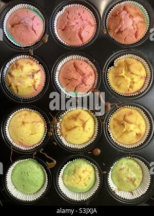 Zwölf bunte, frisch gebackene Muffins in einer Auflaufform Stockfoto