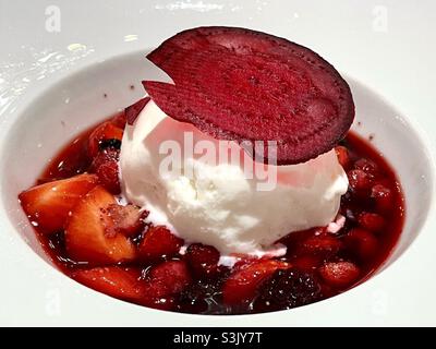 Rote Beeren mit Mascarpone-Eis-Dessert auf dem Teller im Hochzeitslokal Stockfoto
