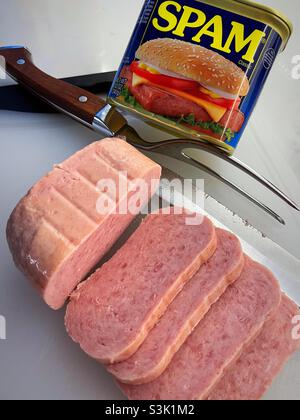 Spamscheiben, gekochtes Schweinefleisch aus der Dose auf einem Schneidebrett mit Messer und Gabel, USA Stockfoto