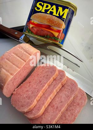 Die Scheiben des gekochten Schweinefleischerzeugnisses spam auf einem Schneidebrett mit einem Messer und einer Gabel, USA Stockfoto