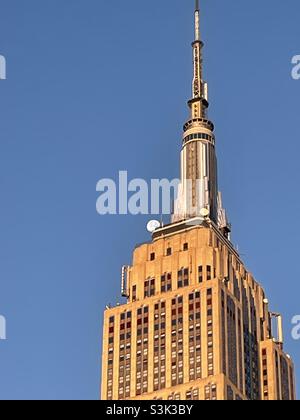 Im frühen Morgenlicht nähert sich der Mond der Spitze des Empire State Building Stockfoto