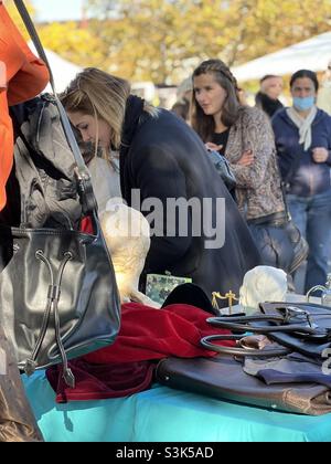 Zürich, Schweiz 10 23 2021 Kunden kontrollieren Waren am Flohmarktstand. Junge Frauen auf dem traditionellen Flohmarkt am Burkliplatz in Zürich. Stockfoto