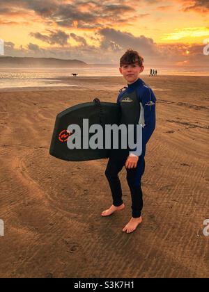 Zwölf Jahre alter Junge Bodyboarding in Westward Ho! Devon, England, Vereinigtes Königreich. Stockfoto