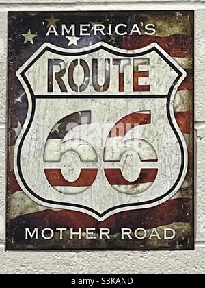 Ein Plakat an der Wand einer Autowerkstatt, das die berühmte amerikanische Straße Route 66, Amerikas Mutter Straße, zeigt. Stockfoto