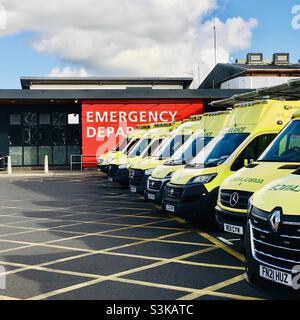 Eine Reihe von Krankenwagen des Gesundheitsdienstes vor einem Unfall und Notfall-A&E im East Surrey Hospital in Surrey England, Großbritannien - vielbeschäftigter Krankenwageneingang des Krankenhauses Stockfoto