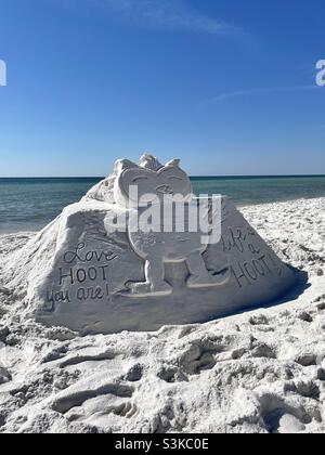 Sandburg am weißen Sandstrand einer Eule mit niedlichen Lebensbotschaften Stockfoto