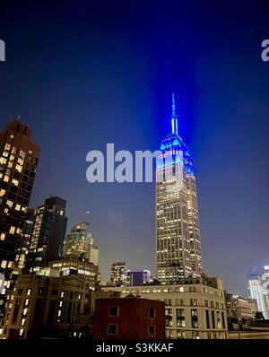 Blaue Lichter auf dem Empire State Building zu Ehren der 30 Jahre Blue man Group Stockfoto