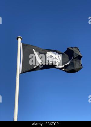 Piratenschädel-Flagge, die im Wind fliegt Stockfoto