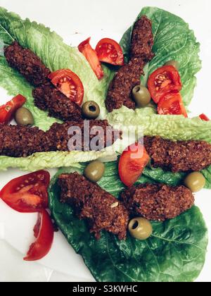 Türkisch-veganes Gericht namens Cig Kofte, das aus Bulgurweizen und einigen Kräutern besteht und mit frischen Salaten serviert wird Stockfoto