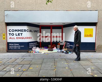 Habseligkeiten einer obdachlosen Person werden am Eingang eines leeren Ladens gesehen, der von Savills am 30. November 2021 in London, England, beworben wird Stockfoto