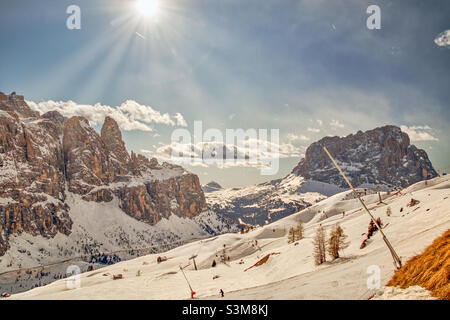 Herrliche Sonne über den verschneiten Skipisten vor den Felsformationen sella Towers und Grohmannspitze mitten in den italienischen Dolomiten Stockfoto